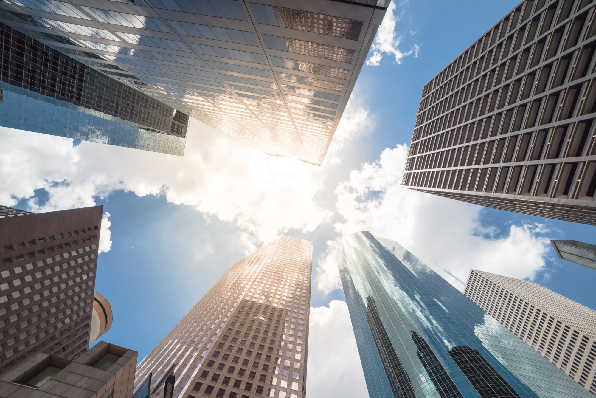 Upward view of skyscrapers against a cloud blue sky in the busin
